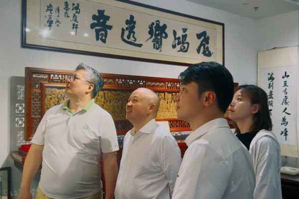 中山市红木家具行业协会会长林志洪（右一）向大家介绍中山红木及大涌红博城的发展情况