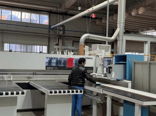 飞美家具智能制造生产线上,工人在对着电脑操作程序